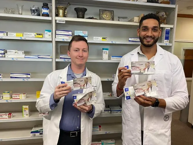 Will Douglas in his pharmacy with his staff member.